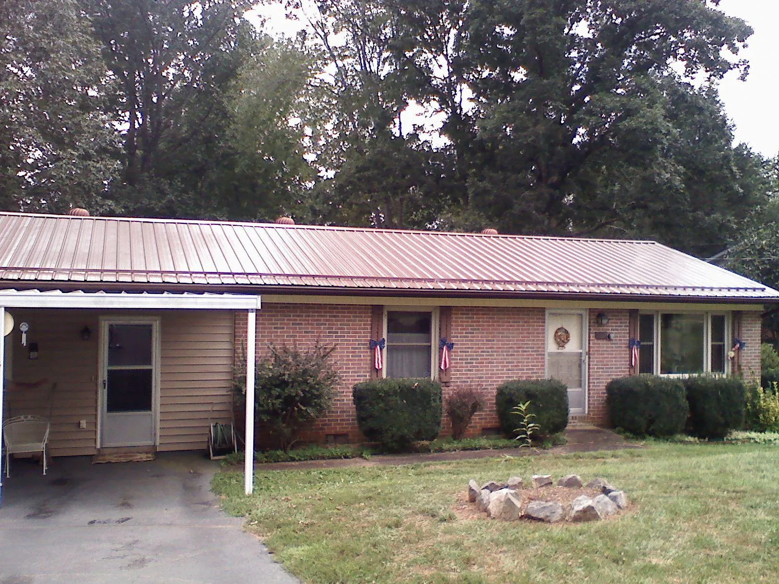 Bronze metal roof and carport on a brick ranch home — Roof Repair work by our crew in Frenchtown